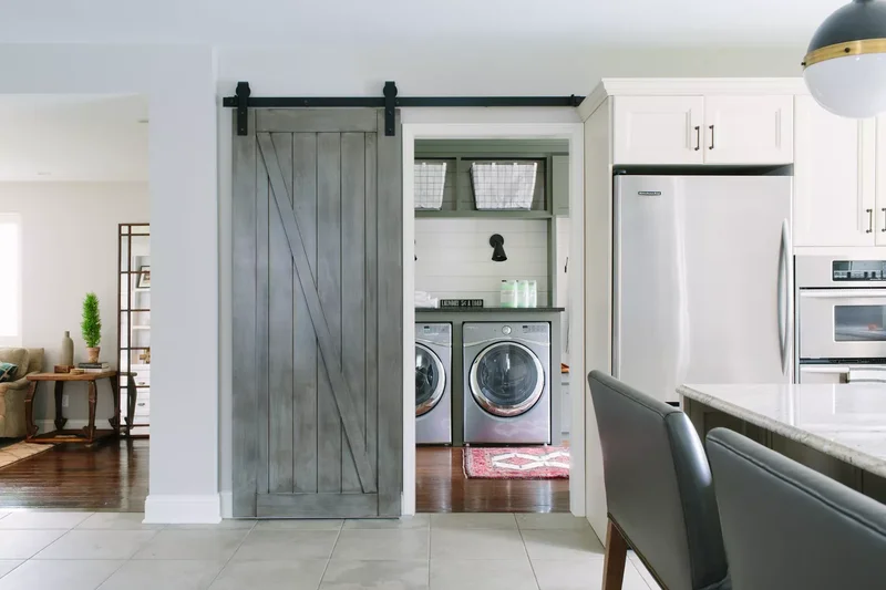 57 Laundry Room Ideas That Make Chores More Enjoyable 16 Hide Behind a Barn Door