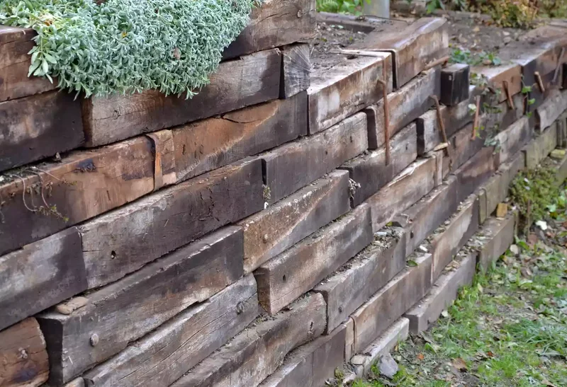 52 Wooden Fence Ideas Brimming with Rustic Outdoor Charm 4 Use a Wood Retaining Wall as a Fence